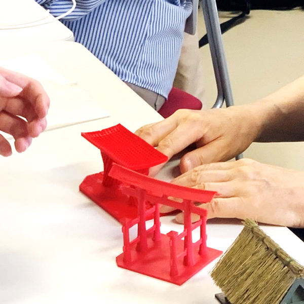 写真:3Dプリンターで作成された模型を触っている様子